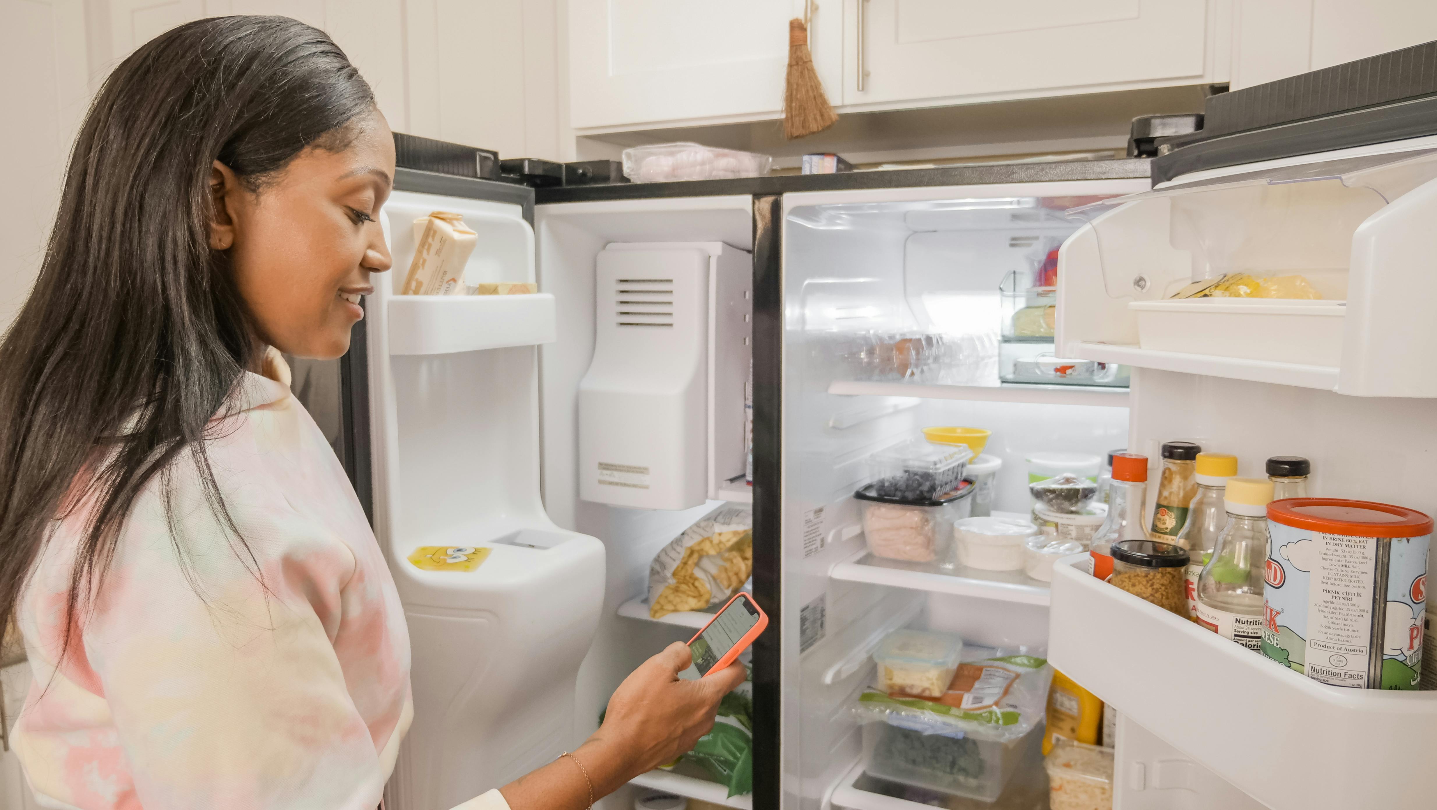 Woman checking phone while planning low-carb meals